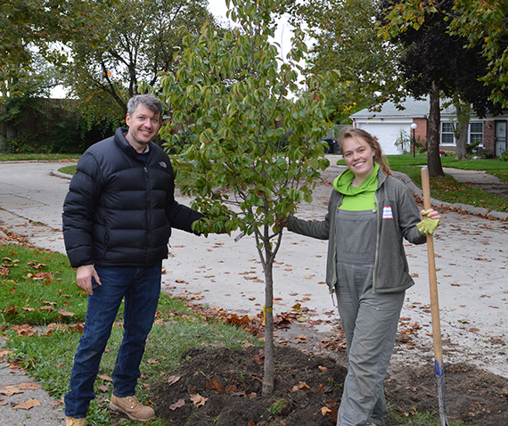 Dan Kinkead and Greening of Detroit volunteer Christanna Schuman plant a tree in Detroit.