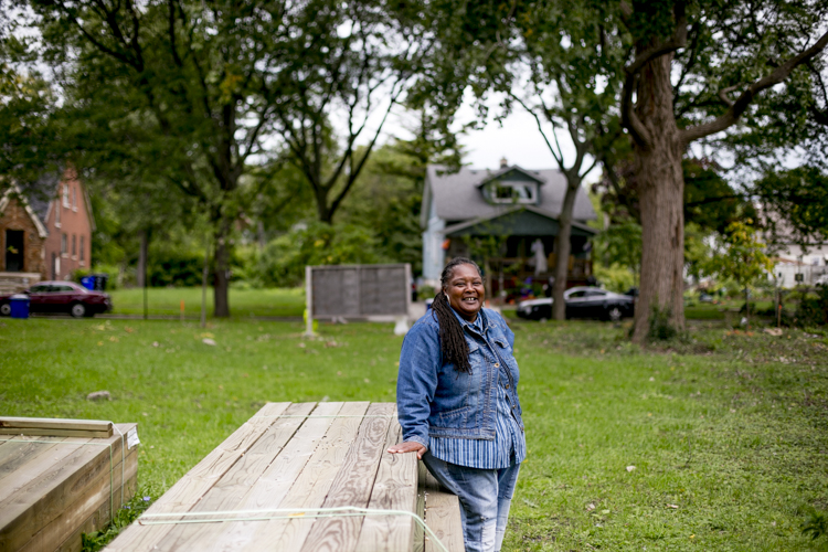 Tammy Black leaning on boards that will be used for the Manistique Community Treehouse Center