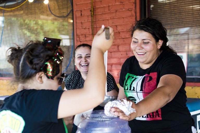 Nancy Lopez, right, and daughter Victoria, 10, preparing a cup of horchata for a customer