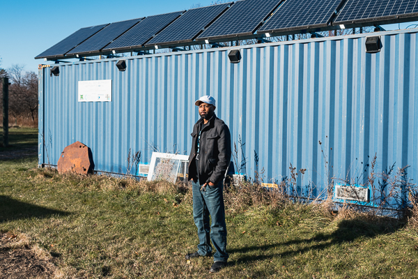 Dirul in front of a shipping container fitted with solar panels