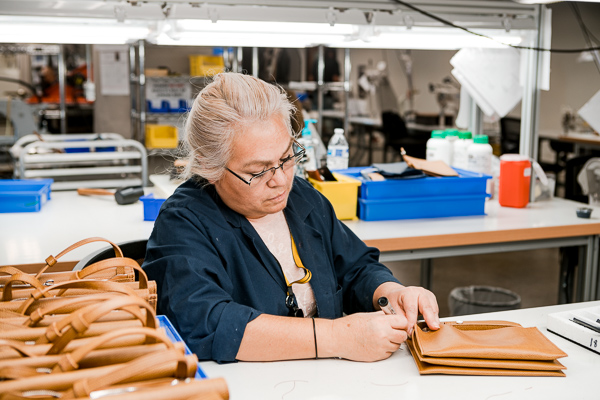 A Shinola worker assembles a leather hand bag