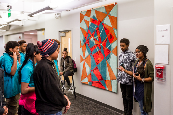 Shelandra Kyles, the art teacher heading up the Hagopian Rug Program for this school year, show her students Underwood's finished rug