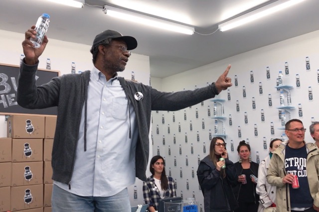 Pope.L auctions a bottle of Flint Water signed by the artist during the opening of Flint Water at What Pipeline - courtesy of the artist and What Pipeline