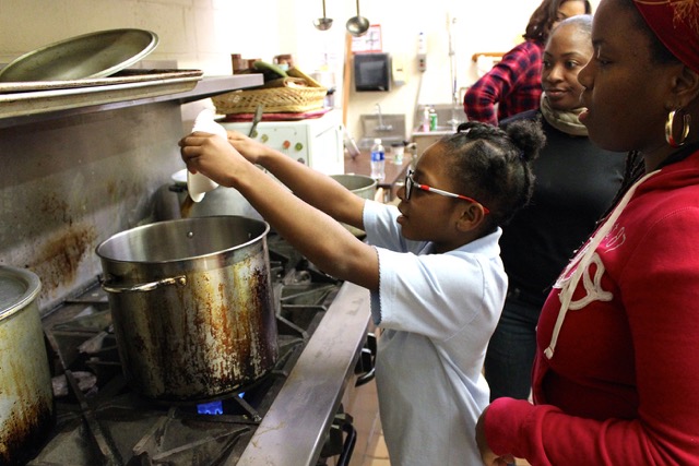 The class's youngest member does the honors with a spice preparation she helped measure