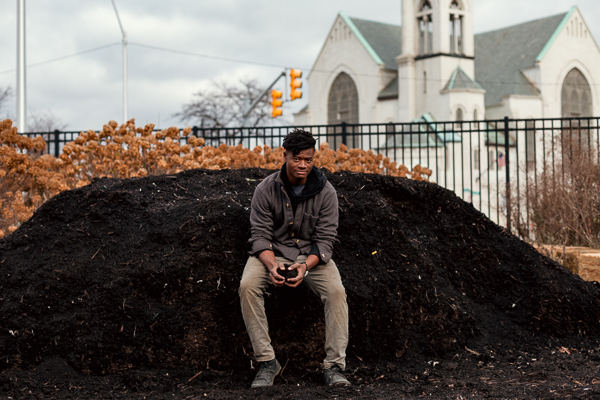 Akello Karamoko sitting on KDG's compost pile