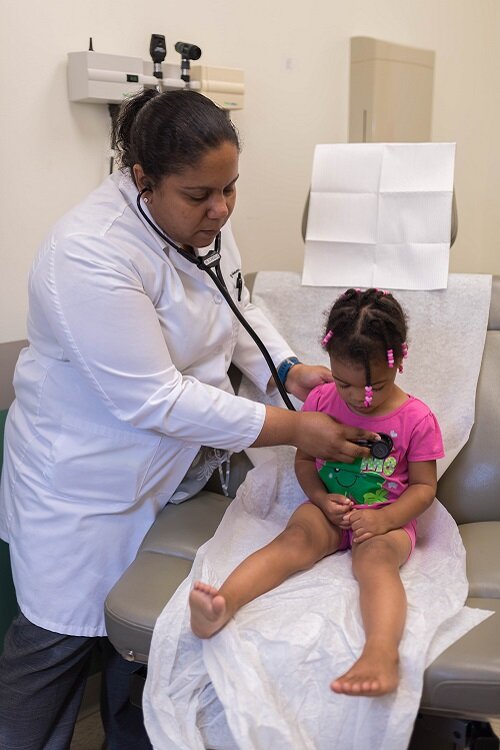 Dr. Prince, a former physician with the Joy Road clinic, attends to a young patient.