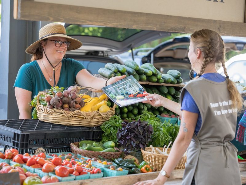 A Farmers Market Food Navigator interacts with a market patron.