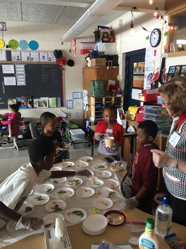 Nutrition Educator Kelly Voelker serves students a healthy snack.