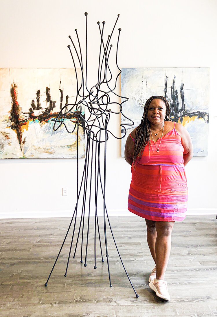 Asia Hamilton poses among art in Norwest Gallery's new exhibit.