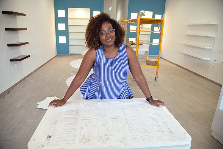 Jamesha Lucas reviews the plans for Bronzed N Glow Beauty Boutique, on Livernois Avenue.