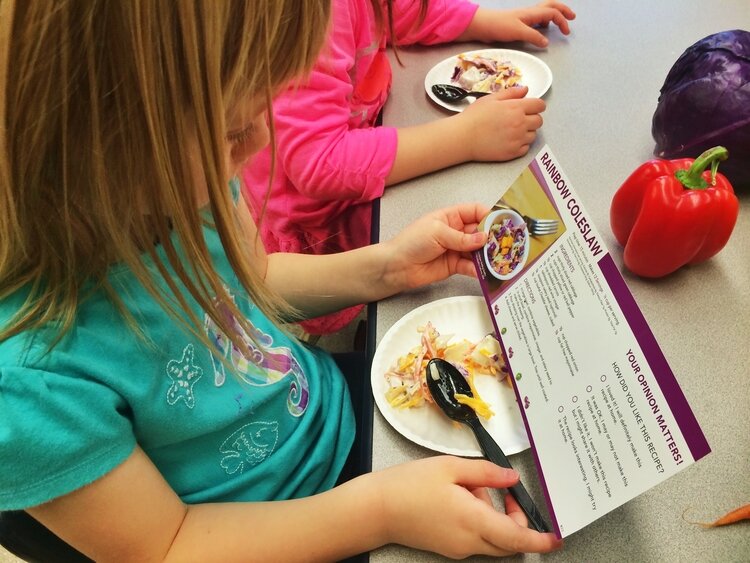 A student studies the recipe card accompanying a food tasting.