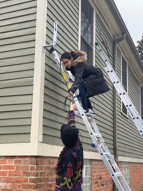 Digital Stewards help UNI install an antenna to extend their internet access into the neighborhood.