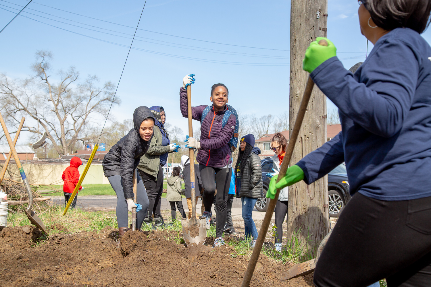 Girls attending a Springboard to Excellence meeting dig a space for flower beds at the Brightmoor Artisans Collective. Photo by Lauren Santucci.
