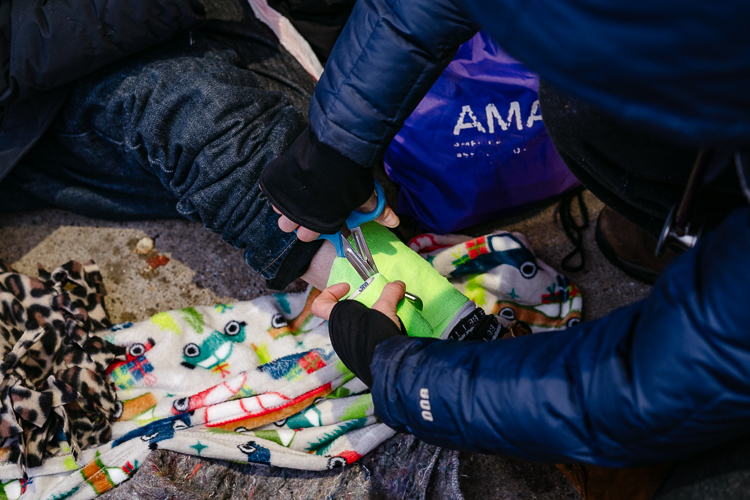 Megan Green wraps a wound on a homeless person's calf