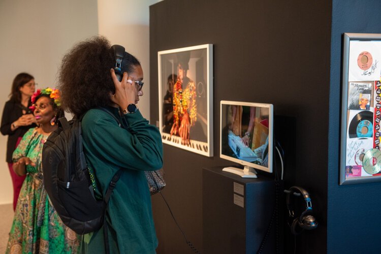 Attendees view photo of Amp Fiddler at the exhibition