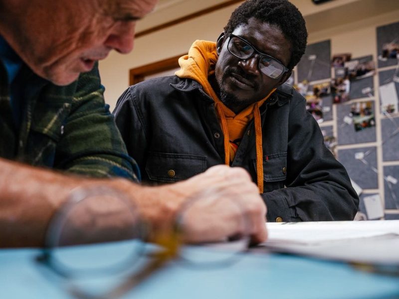 Instructor Kevin Gordon helps Serigne Lo, an ESL student from Senegal, study language needed for a driver's exam