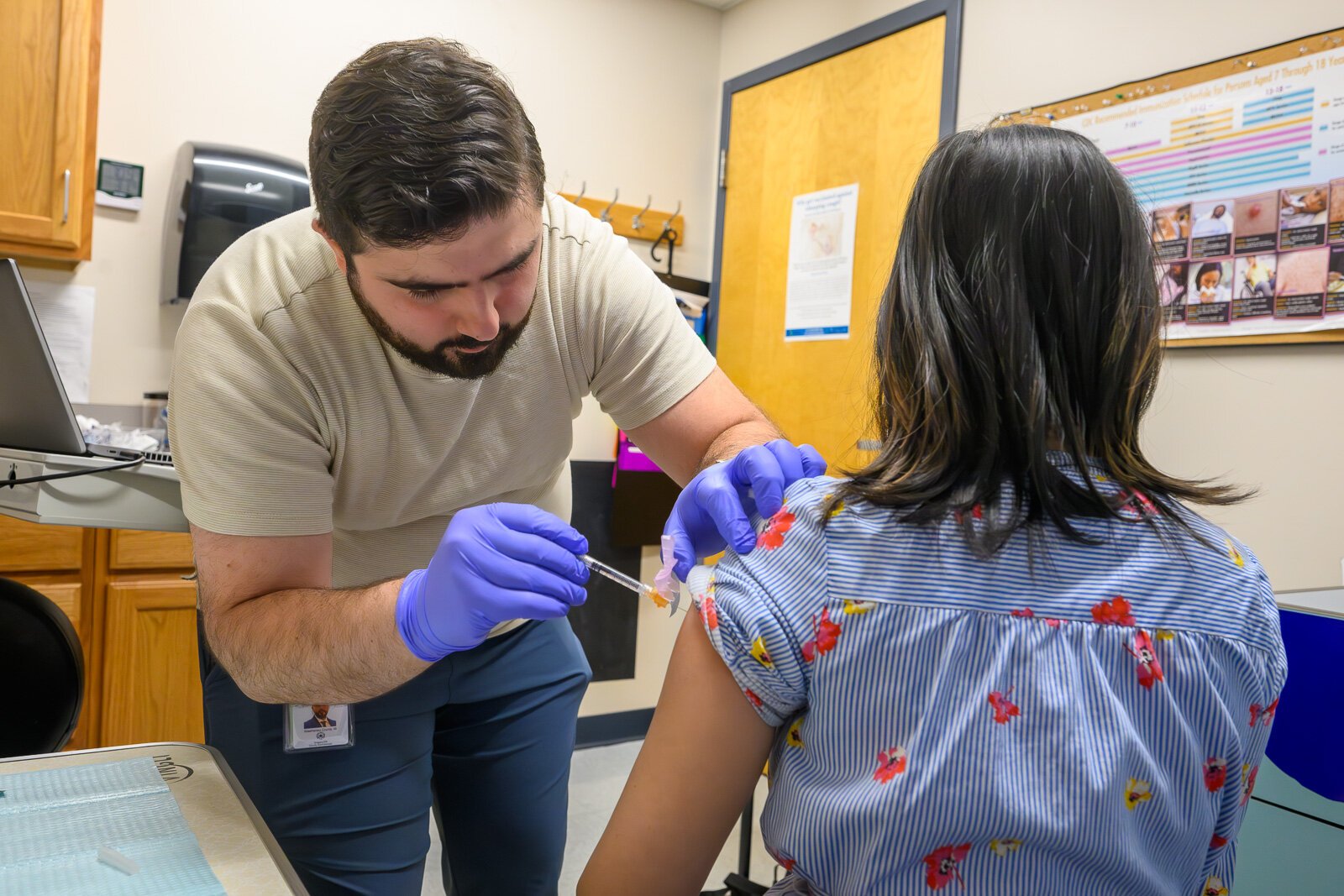 Public health nurse Mikheal administers MMR vaccine.