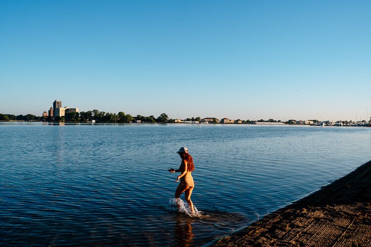 Steph Joseph, a project manager for the swim club, runs into the river.