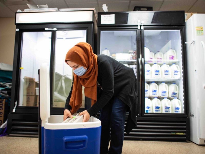 A volunteer puts away food at Jewish Family Services of Washtenaw County
