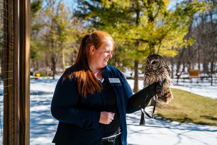 Christina Funk holds Sam on her hand outside. Funk is the Assistant Naturalist and owl handler at the Stage Nature Center.