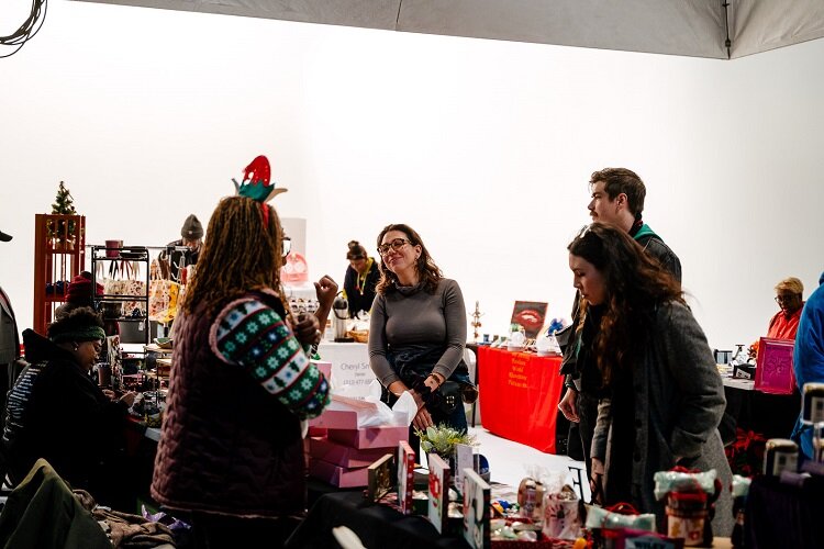 Visitors check out EWDC's holiday market at the Cadieux Stage. (Nick Hagen)