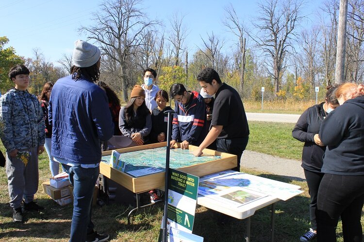 Students from the Academy of the Americas learn about watersheds and water trails from a Friends of the Rouge staff member.
