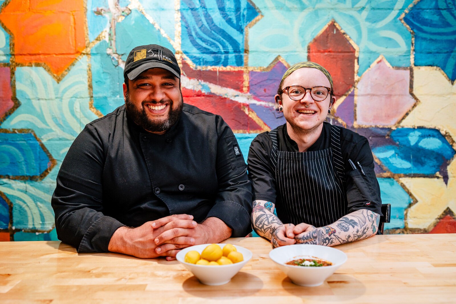 From left, Chef Omar Anani and Artemis McGettigan, who leads the restaurant's efforts with The PLEDGE, pose at a table in Saffron De Twah.
