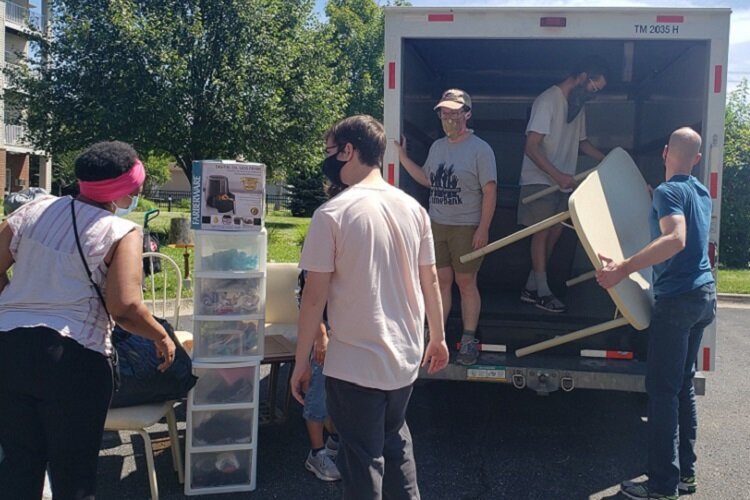 Volunteers help seniors move back into their apartments after summer flooding.
