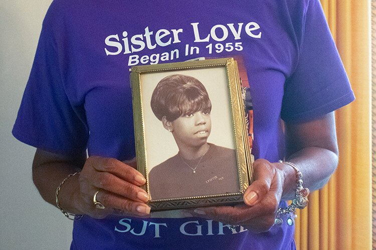 Lynnett Richardson-Brown holds a photo of younger herself as she shares the stories of growing up in the Sojourner Truth Housing Projects. Photo: Zaire Daniels.
