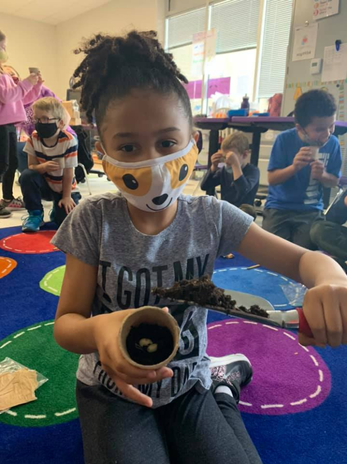 A Minges Brook Elementary student plants seeds for the school garden.