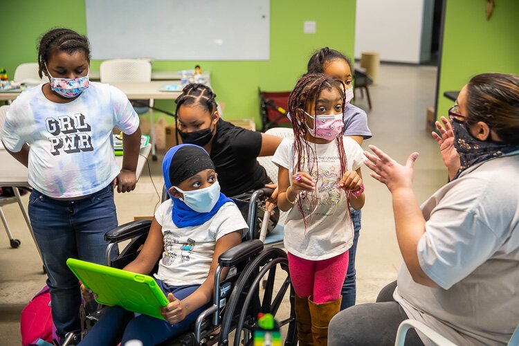 Girl Scouts discuss what they will need to do before building their robots in a Robotics workshop offered through the Girl Empowerment Program.
Photo by David Lewinsky