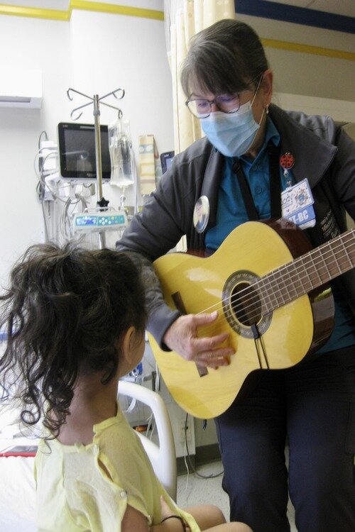 Jody Conradi Stark plays for a patient at Children’s Hospital as part of a music therapy session.