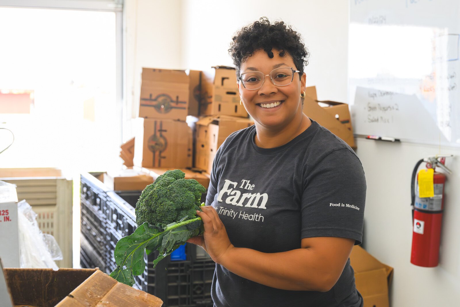 Alison Shores, food program coordinator at The Farm at Trinity Health in Ypsilanti, packs produce boxes.