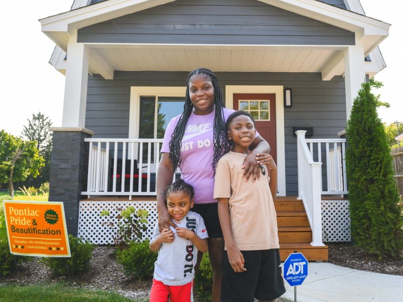 Dayton, Jamillyah, and Dallas Palmer outside their new home in Pontiac.
