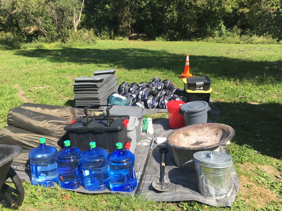 Camping gear staged for a youth campout in Scout Hollow.