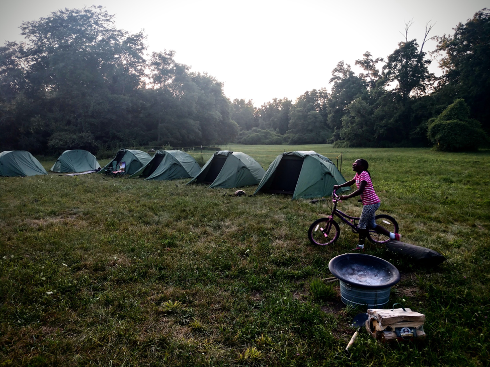 A camper looks across Detroit Outdoors tents set up in Scout Hollow Campground in Rouge Park. 