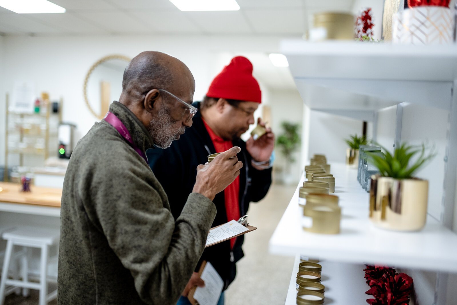 Food and Friendship Connections participants Waymond Barks and Stafford Sykes pick out scents for candles during a social outing to Wicksup Candle Co. in Oak Park.