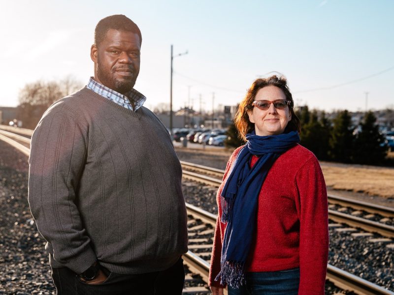 Former Transit Riders United (TRU) board President Donald Stuckey and TRU Executive Director Megan Owens stand by the Amtrak line in Dearborn.