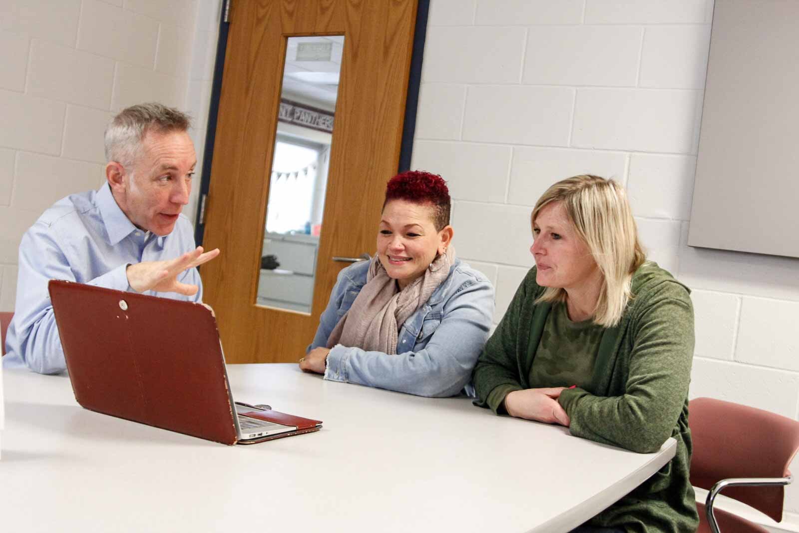 Ethan Alexander, Behavior Specialist Mary Carter, and Principal Lindsey Newton confer at Kalamazoo's Northwood Elementary.