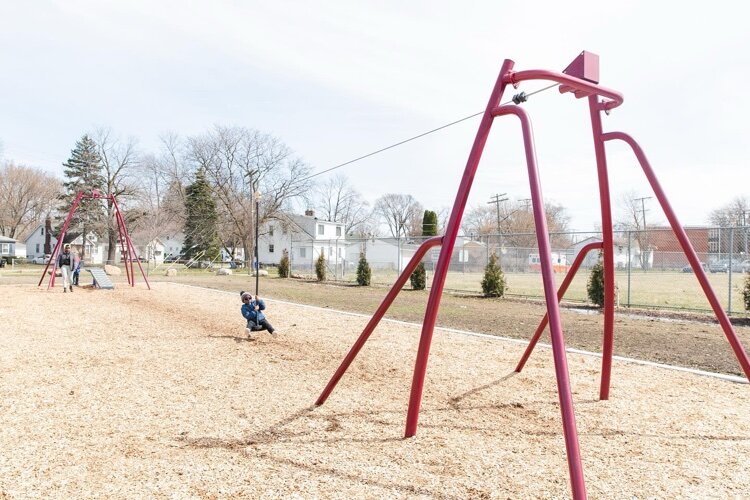 Children from the community using upgraded playground equipment.