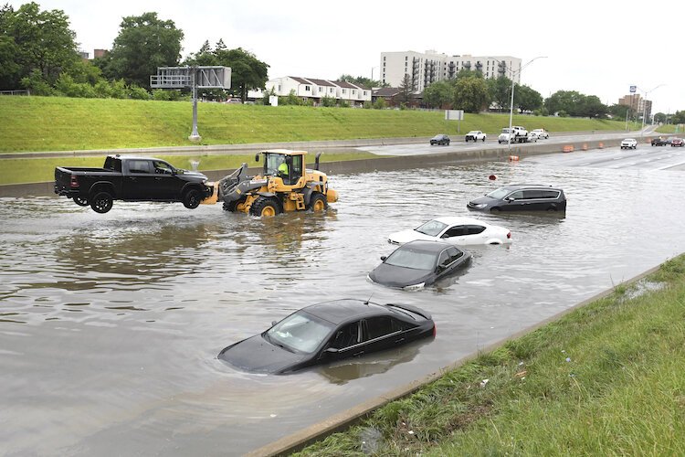 A truck is hoisted from a flooded Interstate 75 in Detroit in June 2021.
